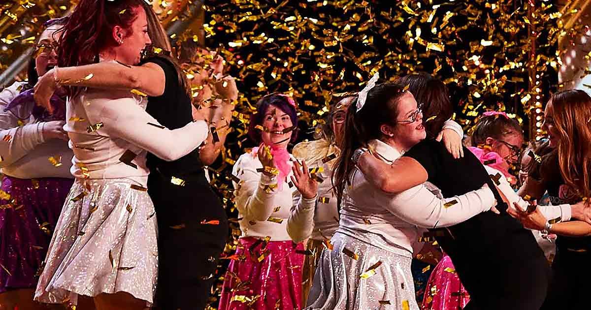 A group celebration indoors with festive attire and confetti falling throughout the scene; evening or nighttime lighting illuminates a gathering of young adults in various colors.