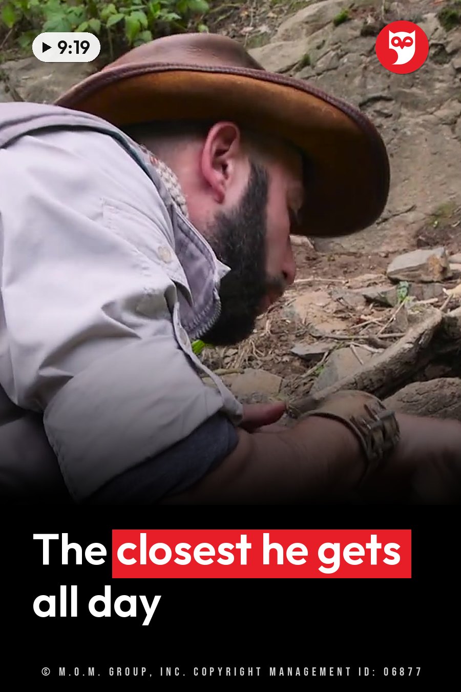 A man with a beard and a hat leans forward and looks at the ground near rocks and plants. A headline runs in white letters across the lower third.