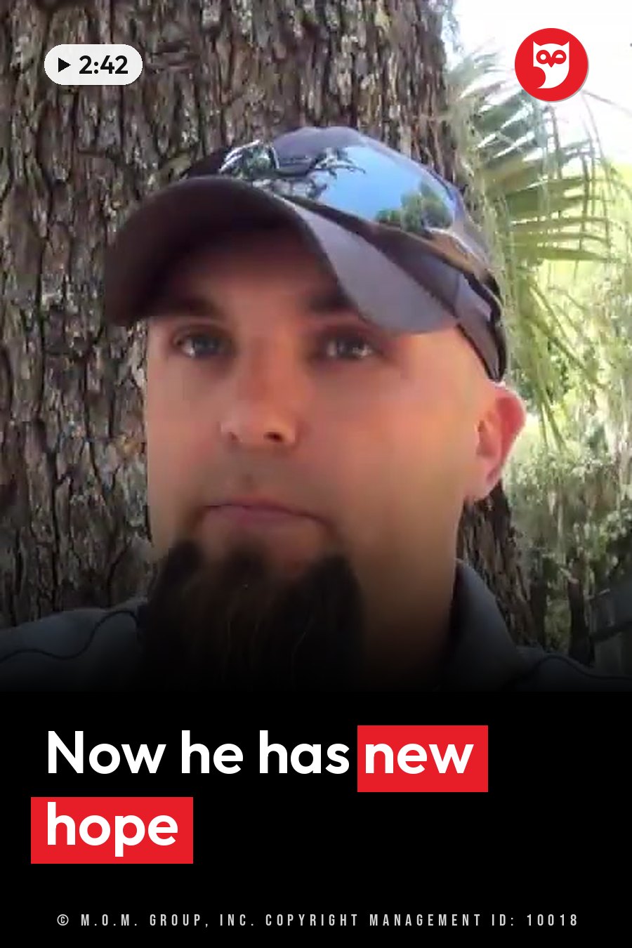 Erick Scott, in a cap and sunglasses, stands beside a tree trunk outdoors with one hand near his beard. A headline runs in white letters across the lower third.