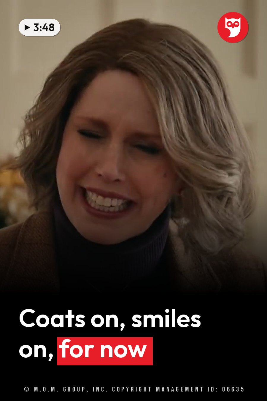 A woman with short brown hair smiles widely, wearing a dark turtleneck under a coat. A headline runs in white letters across the lower third.