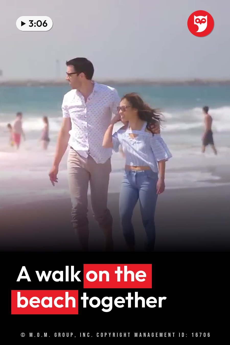 A man and a woman walk along a beach near the water, with other people in the background. A headline runs in white letters across the lower third.